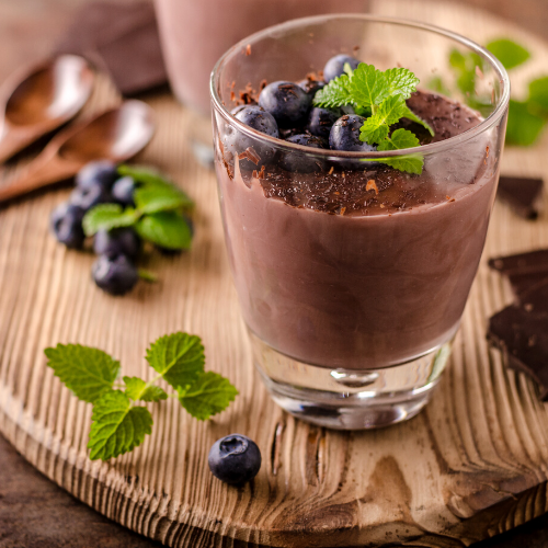 CHERRYLATE PUDDING with chocolate whey protein powder, and top with coconut flakes, almonds and cooked cherries.