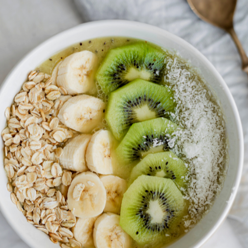 TASTY SMOOTHIE BOWL with kiwi, shredded coconut, sliced almonds and chia seed as toppings.