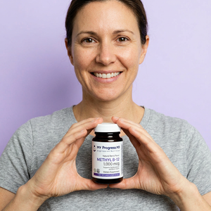 Woman with a warm smile holding a MyProgressMD Methyl B-12 bottle against a light lilac background